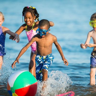 children playing with a beach ball in the water