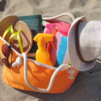 orange beach bag with towels flipflops and supplies