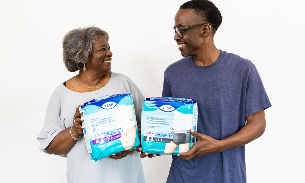 man and woman holding aeroflow packs of diapers