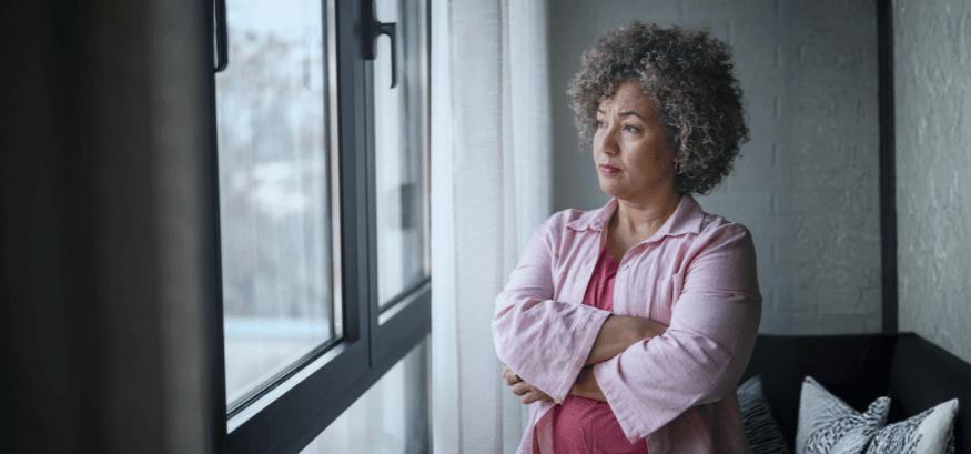 middle aged woman looking out a window