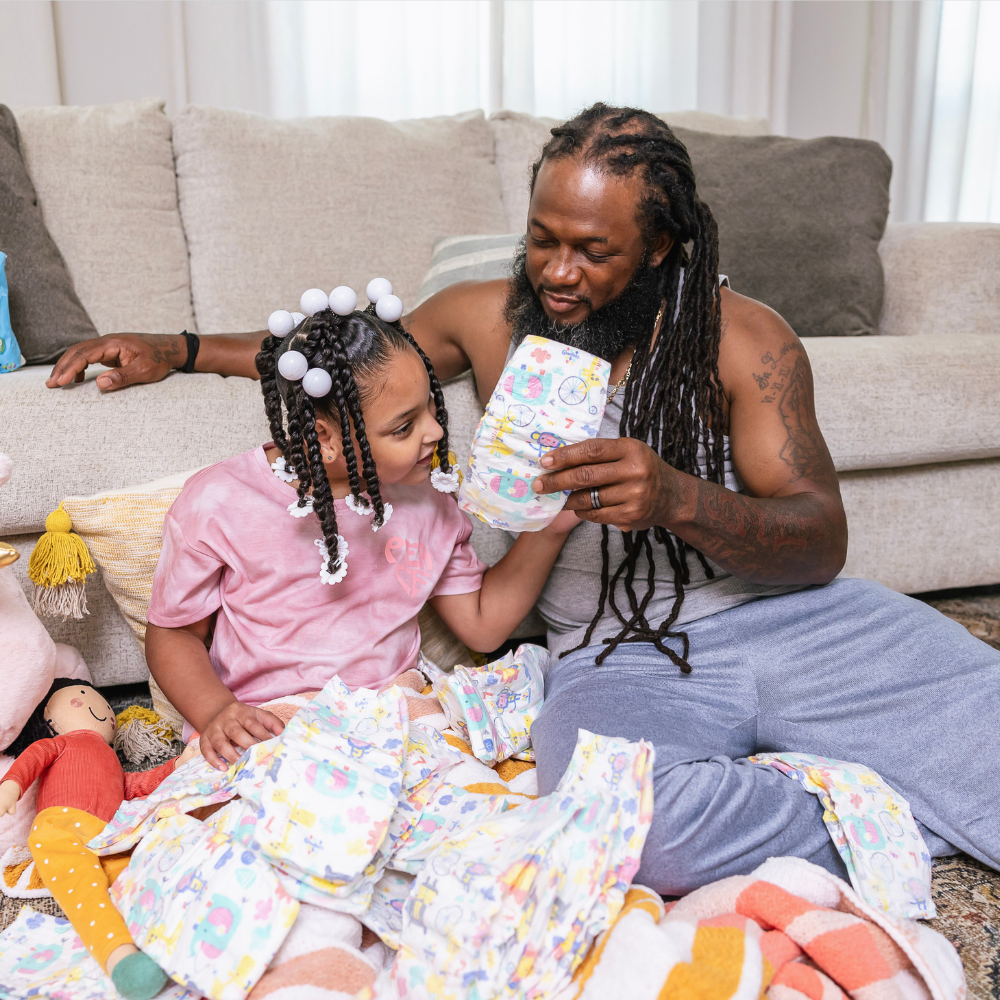 girl holding diapers with dad