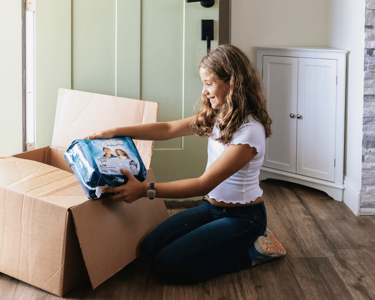 girl unboxing a youth pull-on delivery from aeroflow