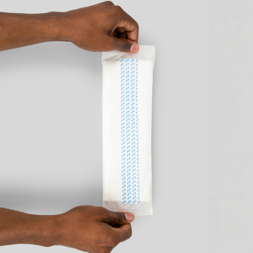 hands holding a booster pad displaying the adhesive back