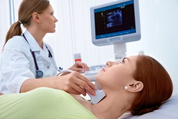Woman at doctor diagnosing hypothyroidism
