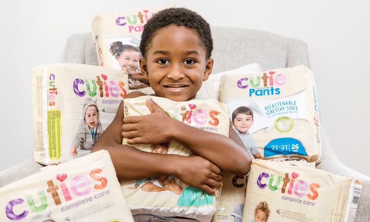 child holding packs of aeroflow diapers