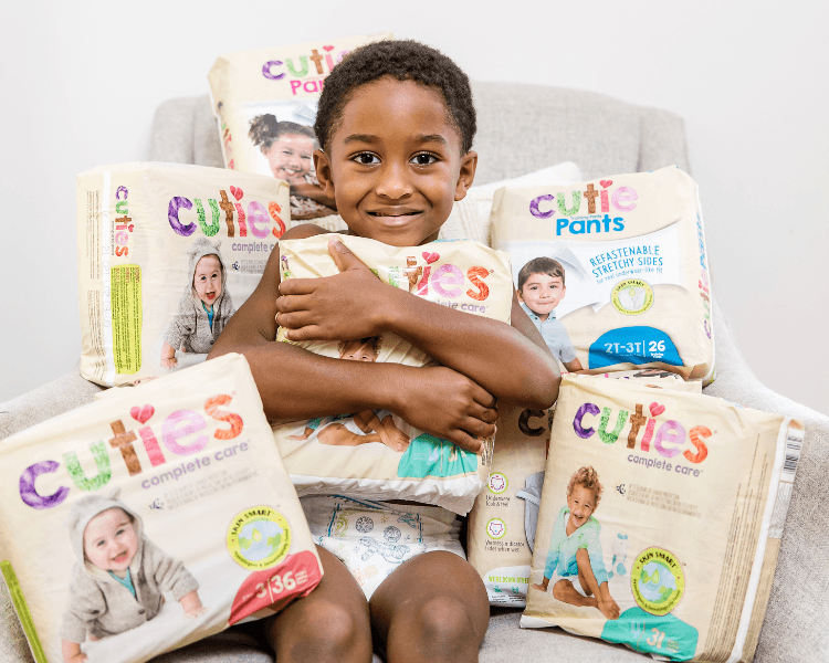 child holding packs of aeroflow diapers