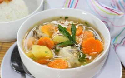 chicken noodle soup with veggies in white bowl