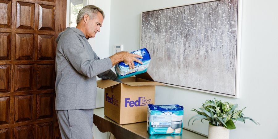 Man opening box of incontinence products