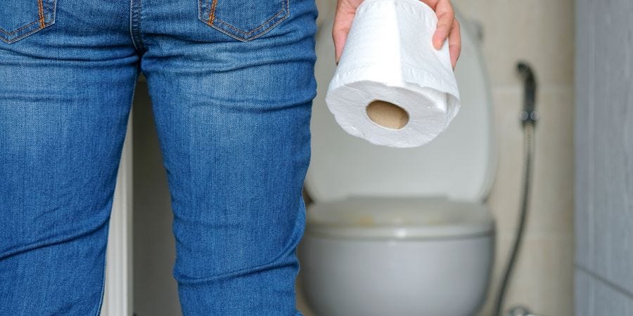 Man holding toilet paper by toilet