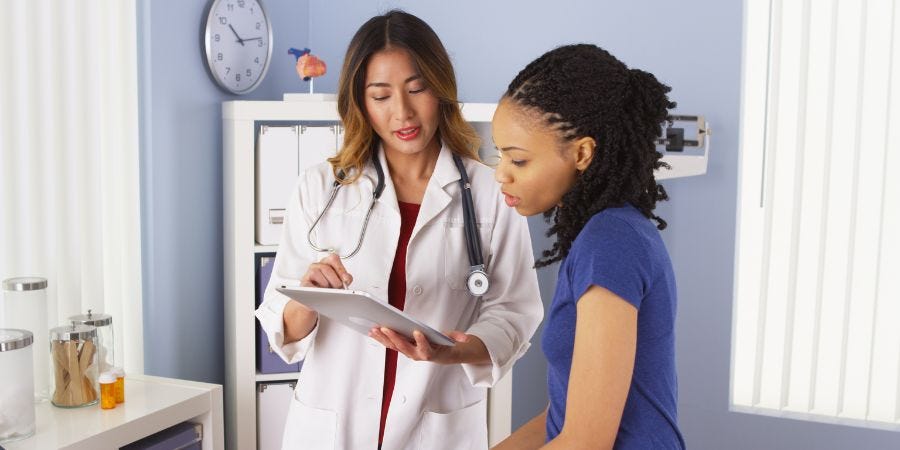 A doctor and patient looking at health information.