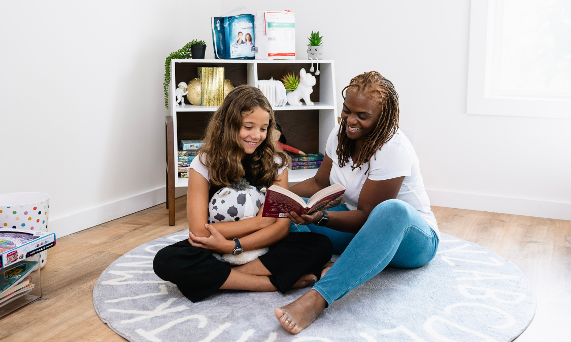 woman and child reading with incontinence products in background