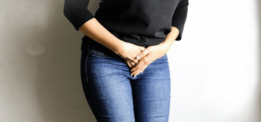 woman having urge to pee holding herself