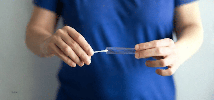 woman holding a saliva test